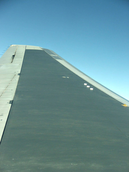 wingtip to space: looking along airplane wing while flying at high altitude