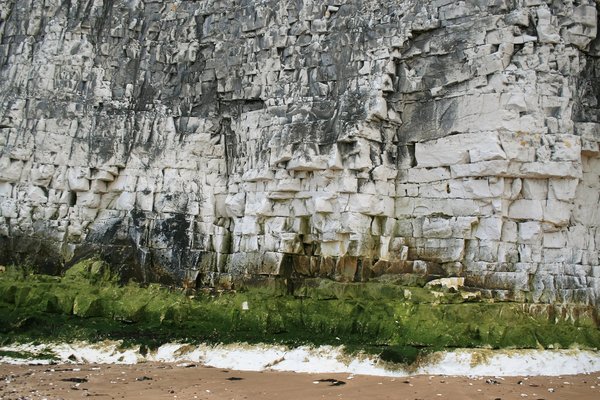 Chalk cliff face: Chalk cliff at low tide on a beach in Kent, England.