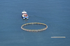 Boat towing a fish pen